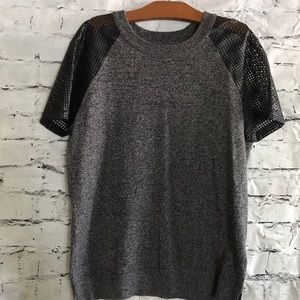 Women’s sweater knit top with mesh inlay sleeves.